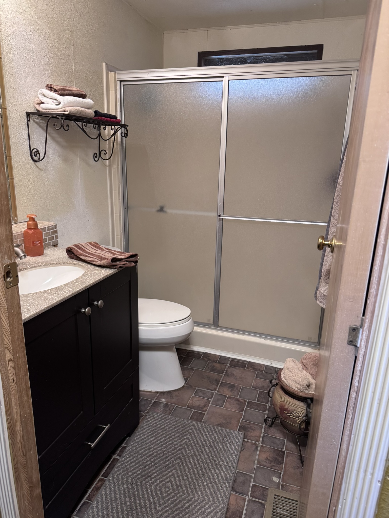 The primary bathroom — walk-in shower and updated vanity
